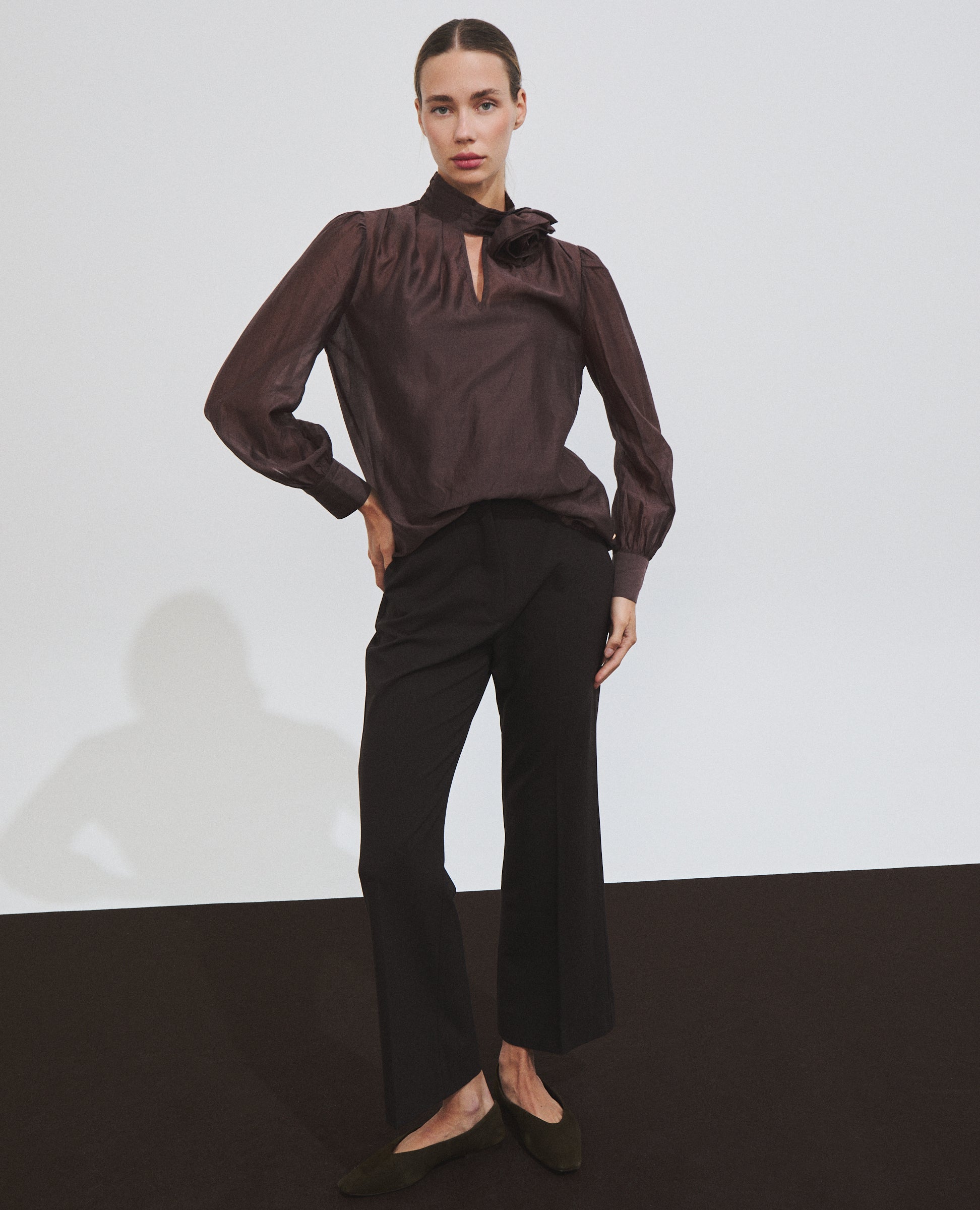 Blusa marrón de manga larga con broche de Hannibal Laguna — detalle del broche