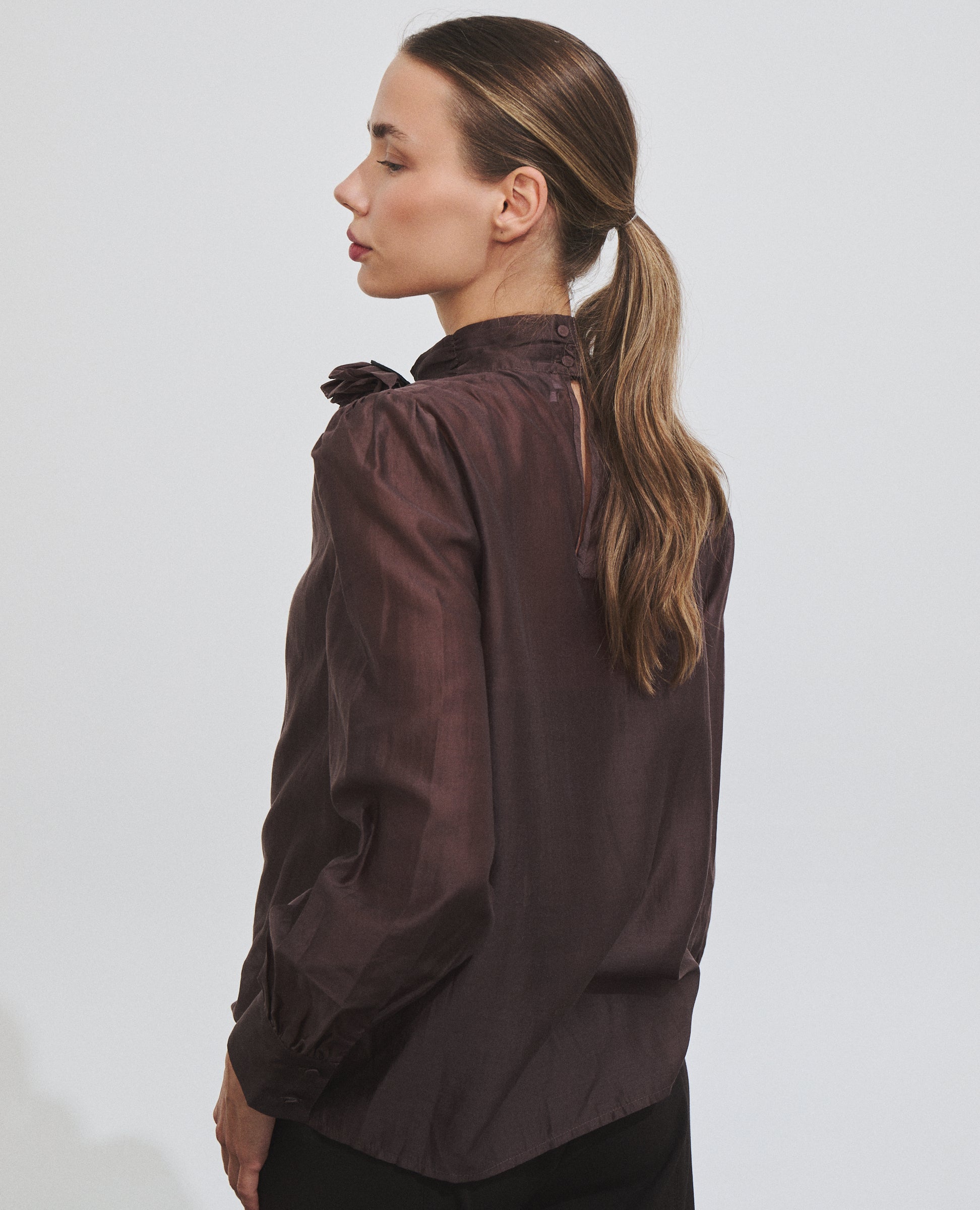 Blusa marrón de manga larga con broche de Hannibal Laguna — vista de espalda